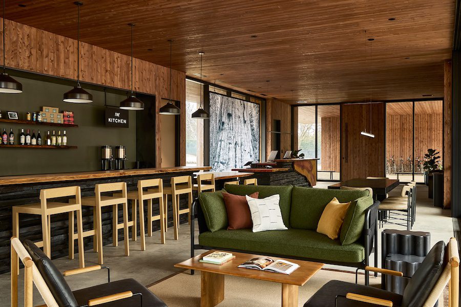 AutoCamp Sequoia Clubhouse Interior green sofa bar light wooden bar stools
